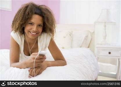 Teenage Girl Lying On Bed Using Mp3 Player