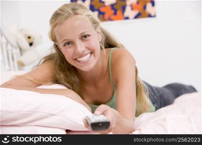 Teenage Girl Lying On Her Bed Changing Television Channels