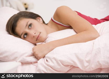 Teenage Girl Lying On Her Bed Looking Sick