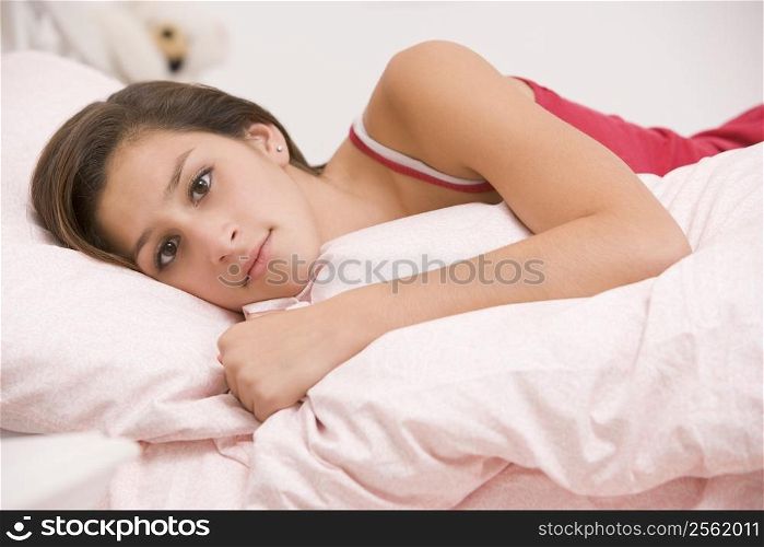 Teenage Girl Lying On Her Bed Looking Sick