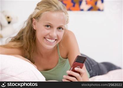 Teenage Girl Lying On Her Bed Using Mobile Phone