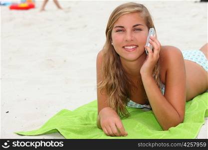 Teenage girl making a phone call on the beach