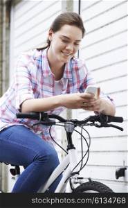 Teenage Girl On Bike Texting On Mobile Phone