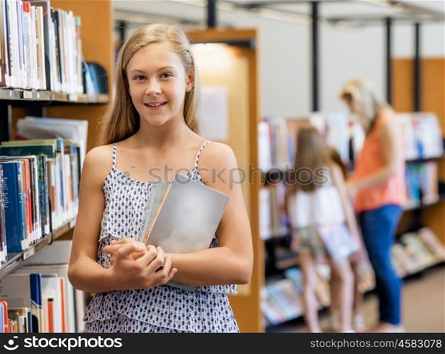 Teenage girl picking a book in public library. That is a difficult choice