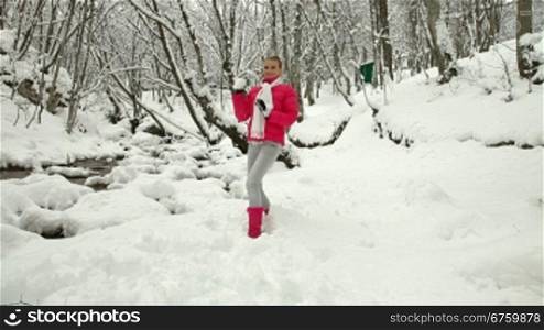 Teenage Girl Playing Snowballs in Winter Forest