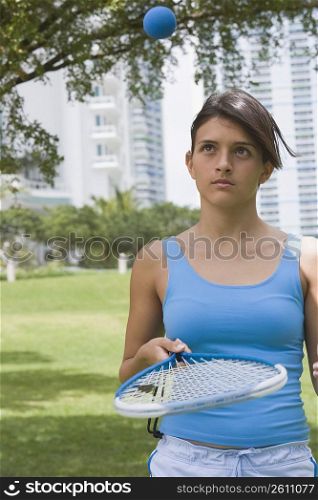 Teenage girl playing tennis in a park