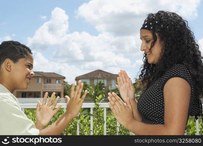 Teenage girl playing the clapping game with a boy