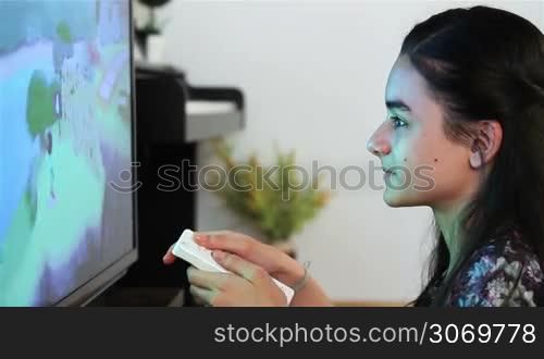 Teenage girl playing video games on smart TV having fun at home