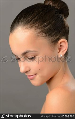 Teenage girl purity skin beauty face looking down on gray