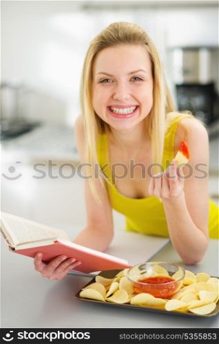 Teenage girl reading book and eating chips
