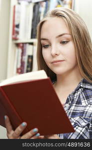 Teenage Girl Reading Book At Home