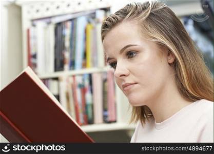 Teenage Girl Reading Book At Home