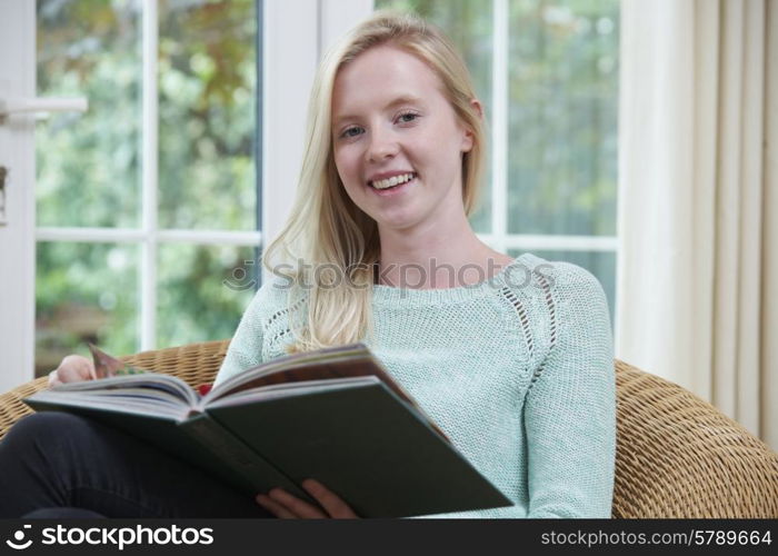 Teenage Girl Relaxing And Reading Book At Home