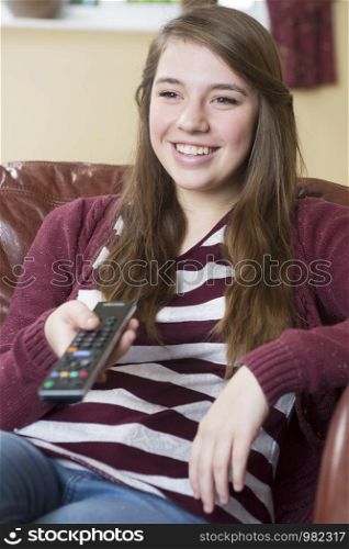 Teenage Girl Relaxing And Watching TV At Home