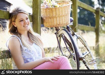 Teenage Girl Relaxing On Cycle Ride In Countryside