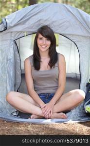 Teenage girl sat in tent