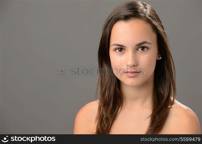 Teenage girl skin beauty portrait natural brunette on gray background
