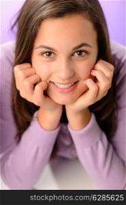 Teenage girl smiling at camera on purple close-up portrait