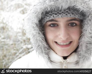 teenage girl smiling at camera while out in the snow