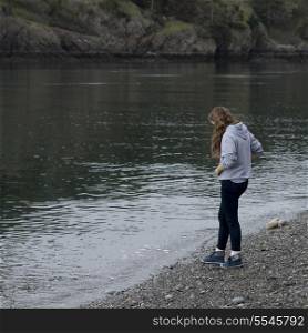 Teenage girl standing at the lakeside, Deception Pass State Park, Oak Harbor, Washington State, USA