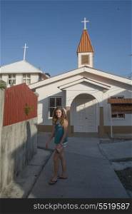 Teenage girl standing in front of a church, Cayman Cay, Utila Island, Bay Islands, Honduras