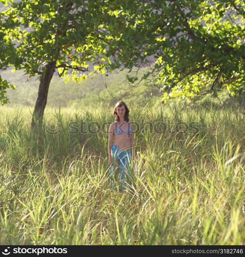 Teenage girl standing in tall grass