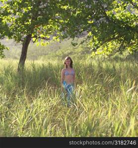 Teenage girl standing in tall grass