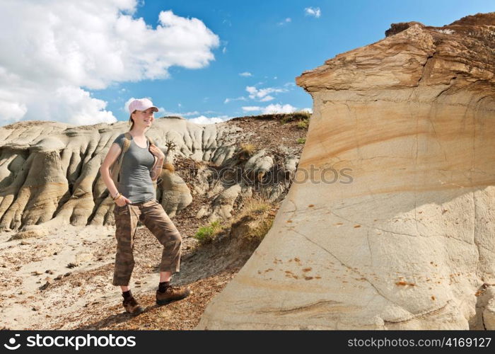 Teenage girl standing near hoodoos in Dinosaur provincial park, Alberta, Canada