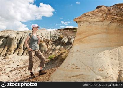 Teenage girl standing near hoodoos in Dinosaur provincial park, Alberta, Canada