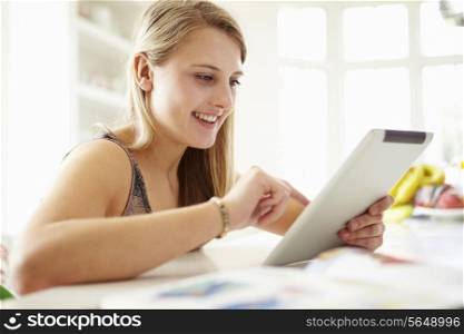 Teenage Girl Studying Using Digital Tablet At Home