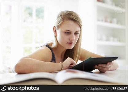 Teenage Girl Studying Using Digital Tablet At Home