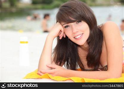 Teenage girl sunbathing on a beach
