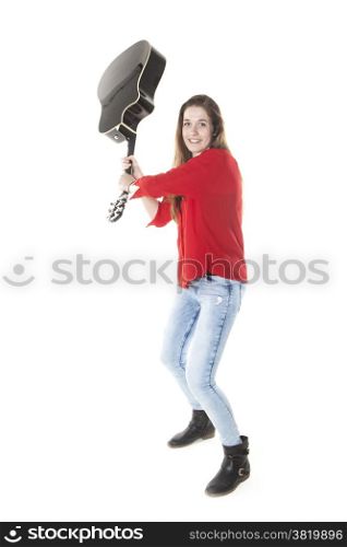 teenage girl swings guitar in studio with white background