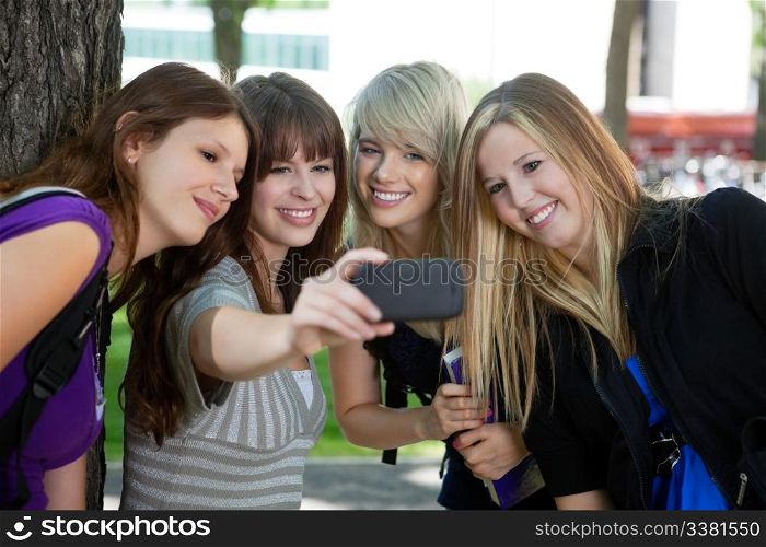 Teenage girl taking a self-portrait of her female friends