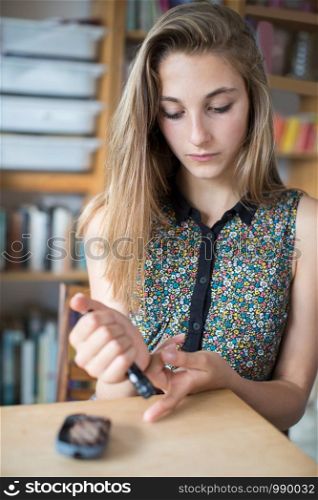 Teenage Girl Testing Blood Sugar Level At Home