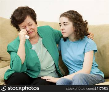 Teenage girl tries to comfort her crying mother.
