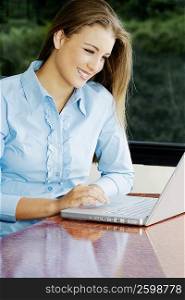 Teenage girl using a laptop and smiling