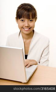 Teenage girl using a laptop and smiling