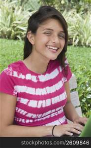 Teenage girl using a laptop and smiling, Miami, Florida, USA