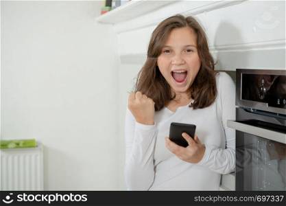 teenage girl using a smartphone in the kitchen