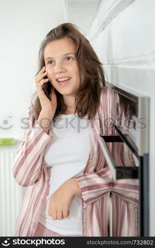 teenage girl using a smartphone in the kitchen