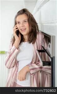 teenage girl using a smartphone in the kitchen