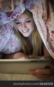 Teenage Girl Using Digital Tablet In Bed At Night