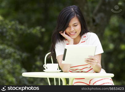 Teenage Girl Using Digital Tablet In Outdoor cafe