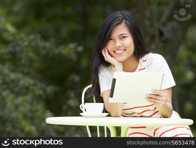 Teenage Girl Using Digital Tablet In Outdoor cafe