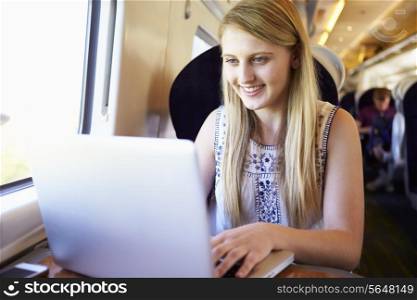 Teenage Girl Using Laptop On Train Journey