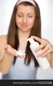 Teenage girl using makeup removal on white background