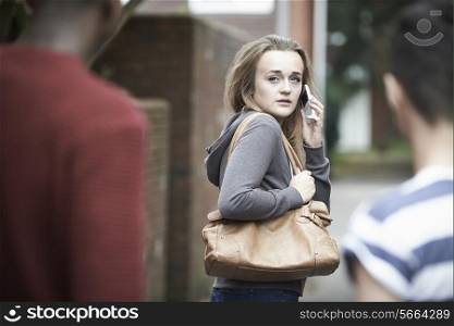 Teenage Girl Using Phone As She Feels Intimidated On Walk Home