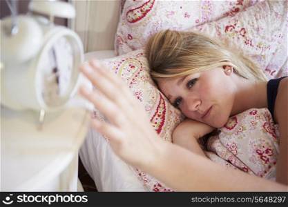 Teenage Girl Waking Up In Bed And Turning Off Alarm Clock
