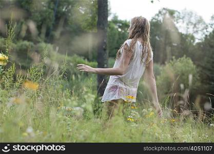 Teenage girl walking on wildflowers